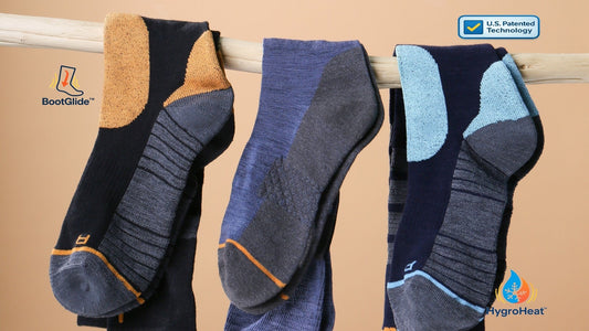 Close-up of Laetts performance socks hanging on a wooden rod, showing cushioned heel/toe and instep panels with BootGlide™ and HygroHeat™ icons—banner for patent announcement to innovation story
