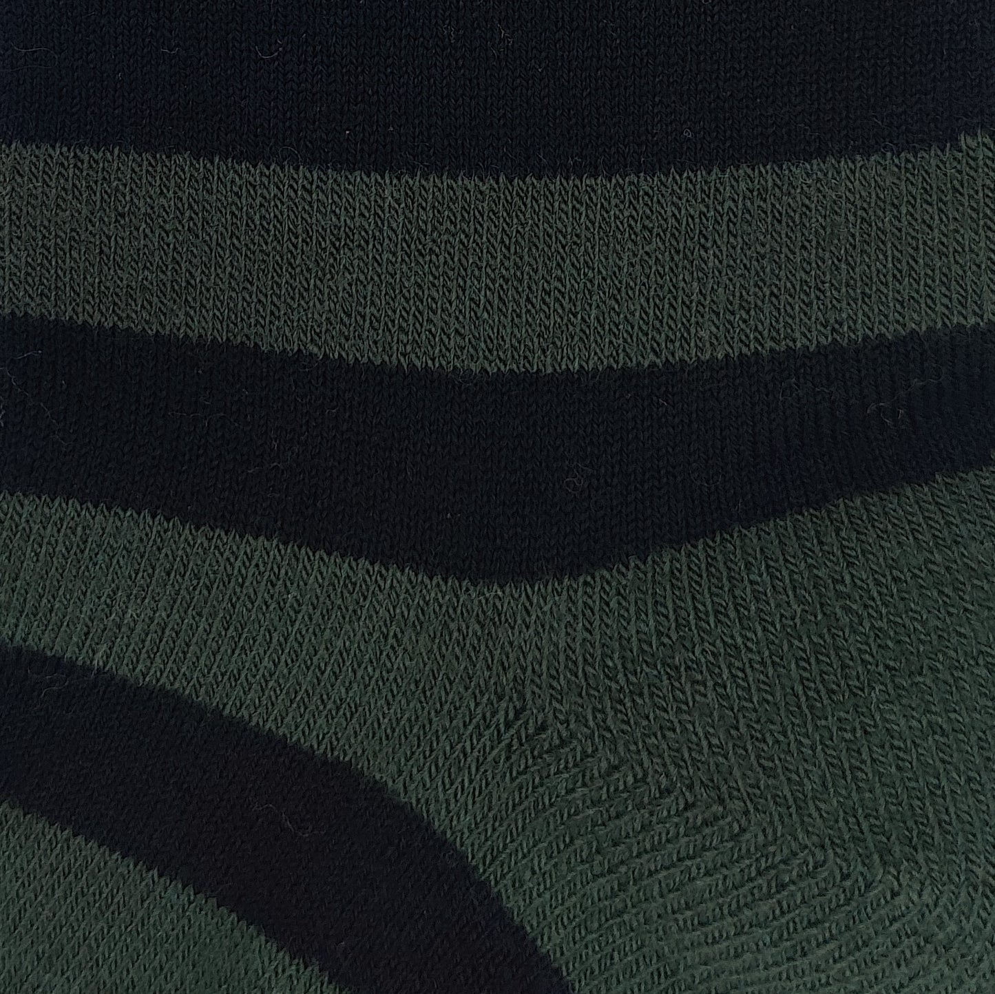 Close-up texture detail of Laetts green and black Merino wool crew socks featuring patent-allowed HygroHeat™ thermal yarn.