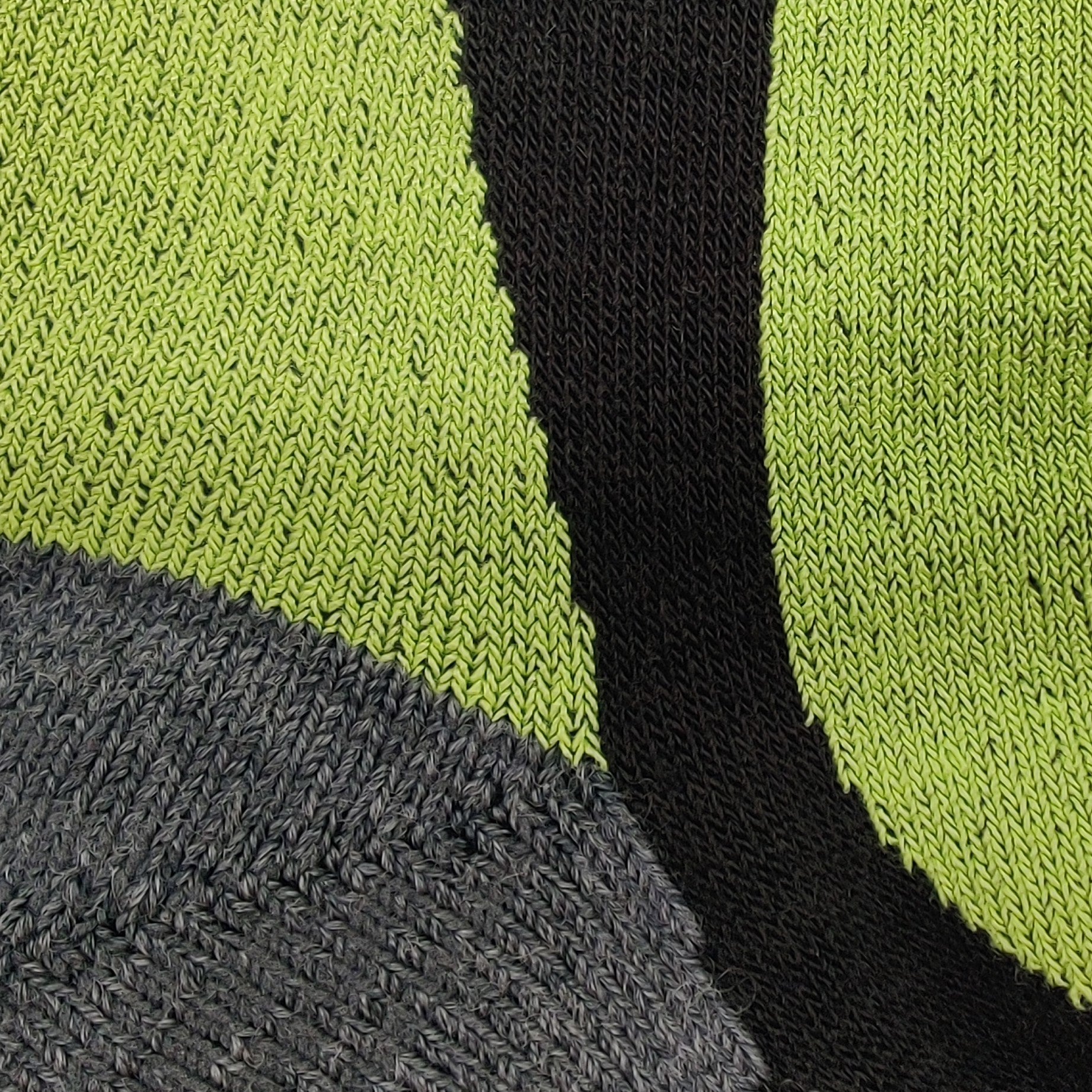 Close-up detail of Laetts women’s Light Snowboard BootGlide™ sock showing the knit texture and color zones: bright green BootGlide™ low-friction panel, black performance knit section, and gray Merino wool reinforcement. Highlights the patented BootGlide™ zone and technical fabric structure.