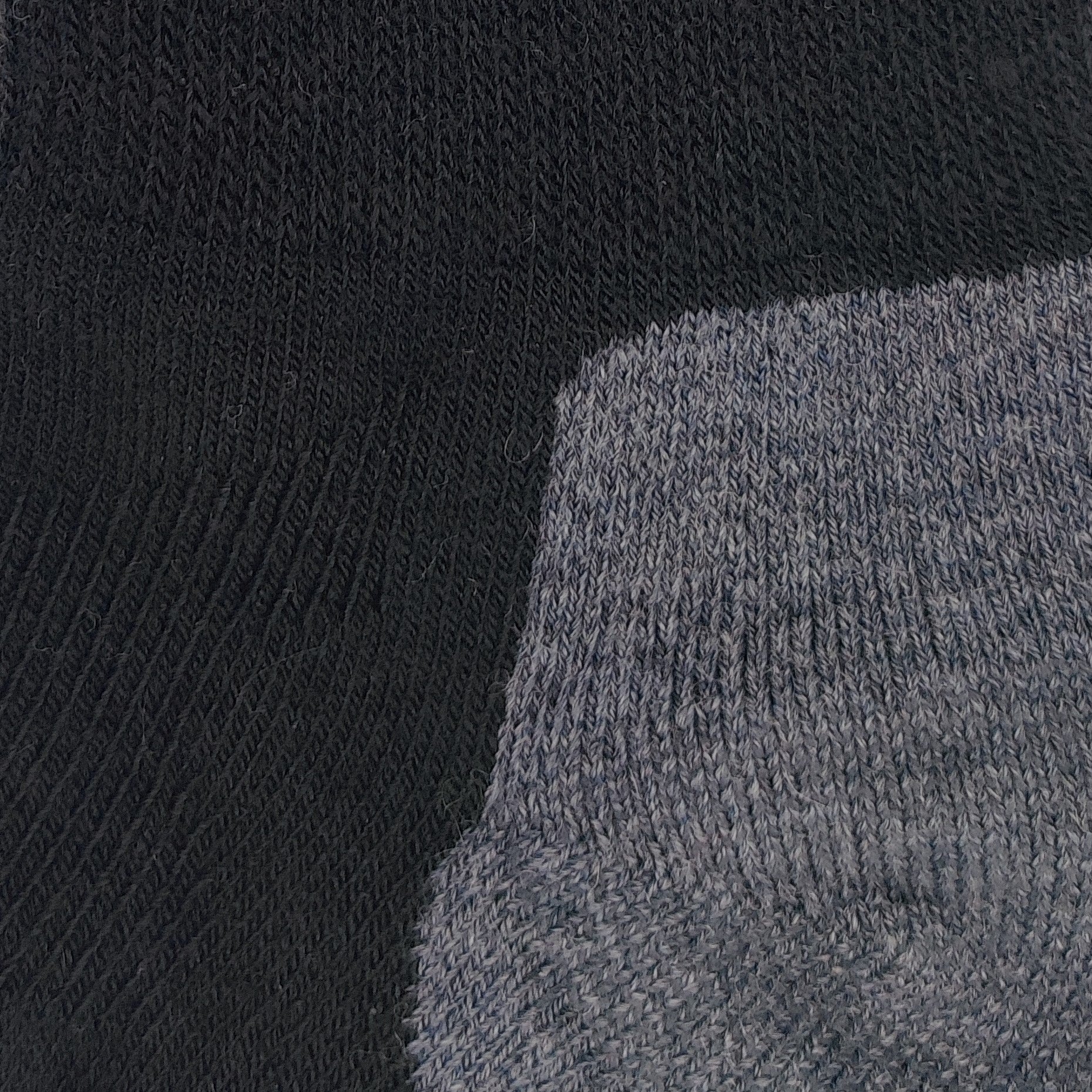 Close-up texture detail of Laetts black medium hiking crew socks made with Merino wool and patent-allowed HygroHeat™ thermal yarn.