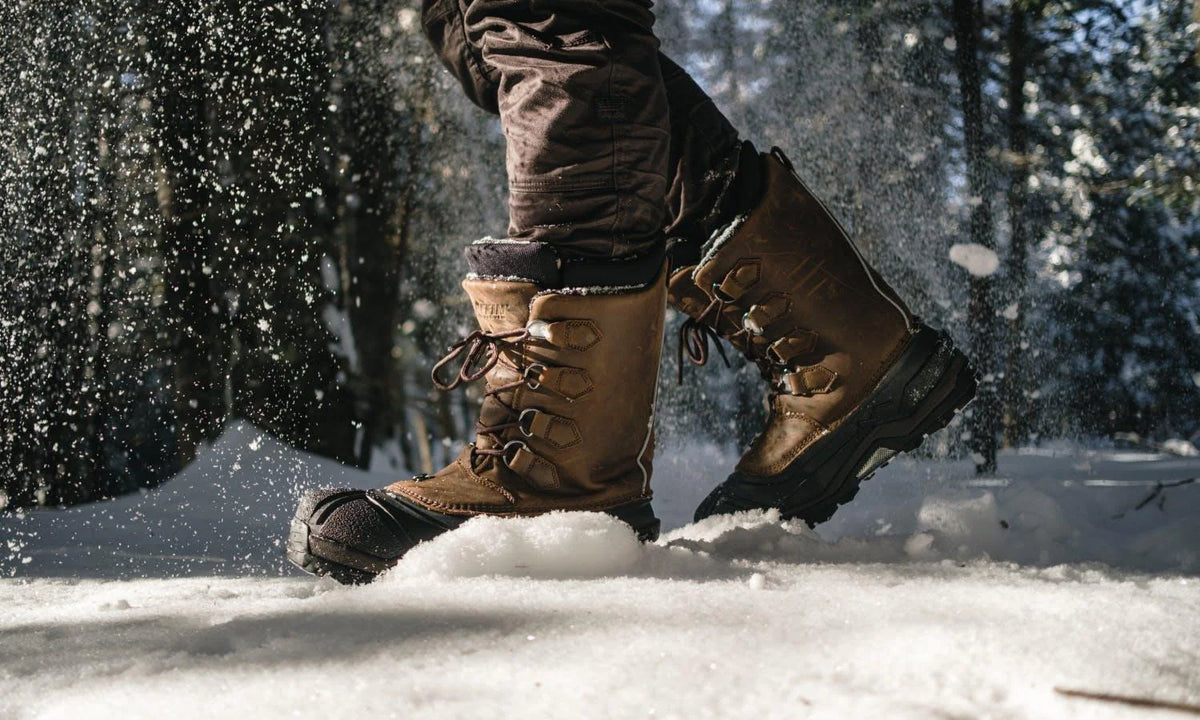 Cold-weather winter boots walking through snow, illustrating LAETTS Adaptive Warmth Performance technology designed for warmth, moisture management, and comfort inside outdoor footwear.