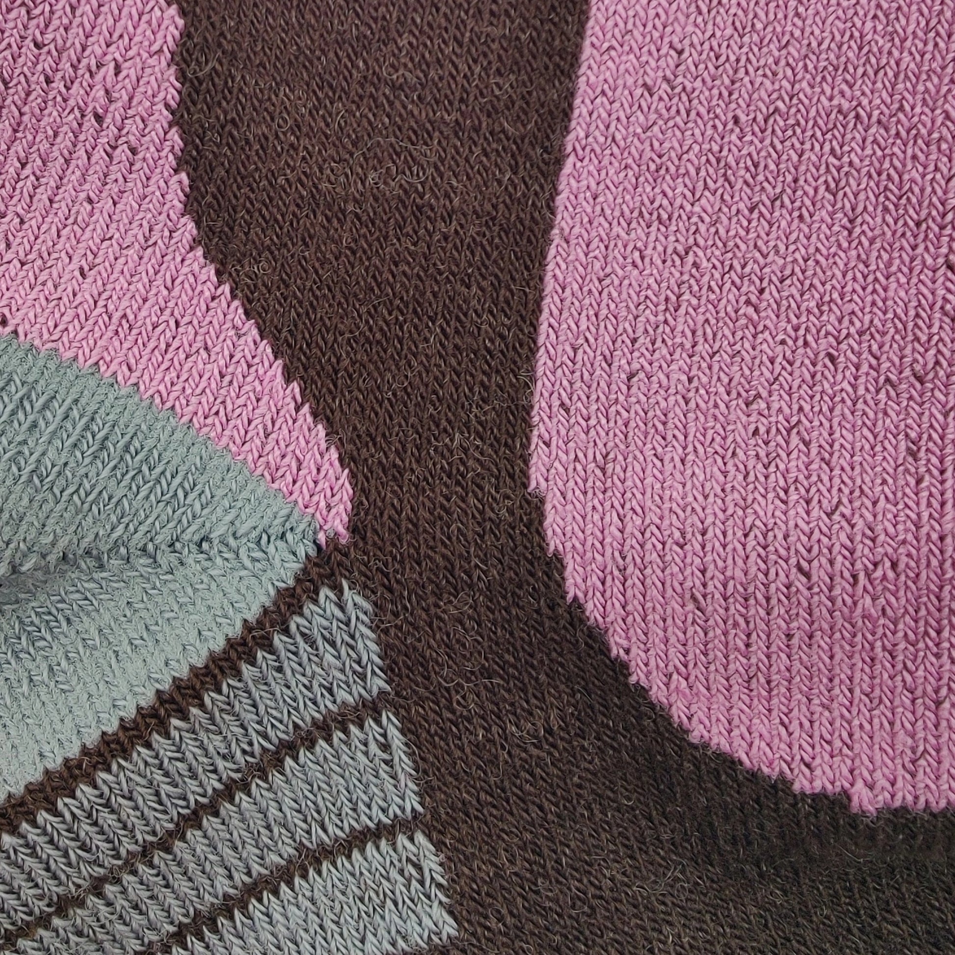 Close-up detail of Laetts women’s Ultralight Ski BootGlide™ sock showing the knit texture and BootGlide™ low-friction zone in violet. The image highlights the brown Merino wool base fabric, gray reinforced areas, and patented construction designed for smooth boot entry and warmth from HygroHeat™ technology.